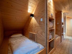 a small room with a bed in a wooden cabin at Holiday home in Petten with garden in Petten