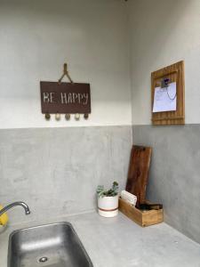 a kitchen sink with a sign that says be happy at Departamentos Galarza Alojamiento en Concepción del Uruguay in Concepción del Uruguay