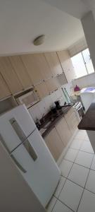 a white kitchen with a sink and a counter at Encontre seu lar perfeito in Barretos