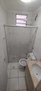 a white bathroom with a toilet and a sink at Encontre seu lar perfeito in Barretos