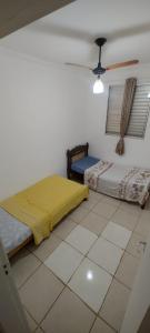 a bedroom with two beds and a ceiling fan at Encontre seu lar perfeito in Barretos
