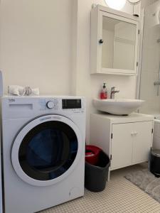 a washing machine in a bathroom with a sink at Lovely condo next to European Area in Brussels