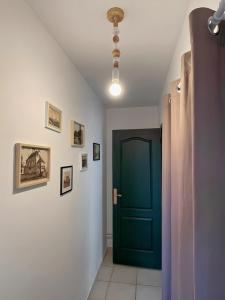 a hallway with a green door and pictures on the walls at Halte à Saint Leu - Maison 5 personnes in Saint-Leu