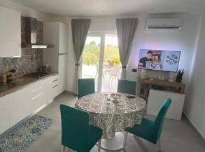a kitchen and dining room with a table and chairs at I Mori di Brucoli in Brucoli
