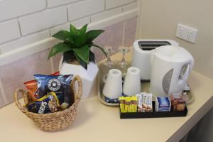 eine Theke mit Snacks, eine Kaffeemaschine und eine Pflanze in der Unterkunft Motel Northview Mackay in Mackay