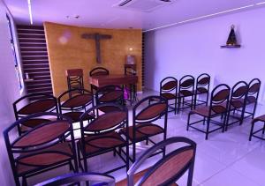 a row of chairs in a room with a cross on the wall at Hotel Rainha dos Apóstolos in Aparecida +34 photos