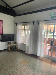 a living room with white curtains and a television at Villa Karel Sea View in Riambel