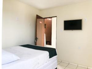 a bedroom with a bed and a flat screen tv at Pousada BR 423 in Garanhuns +22 photos