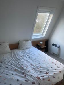 Un dormitorio con una cama grande con ventana. en Strand 104, en Hollum 16 fotos más