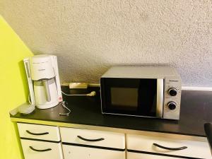 a microwave and a coffeemaker on a counter at Monteurunterkunft, Ferienwohnung in Staufenberg +15 photos