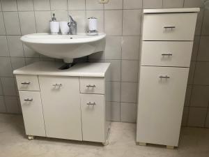 a bathroom with a sink and a white cabinet at Monteurunterkunft, Ferienwohnung in Staufenberg
