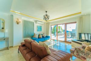 Una sala de estar con un sofá y un televisor. en Villa Olivia, en Kas