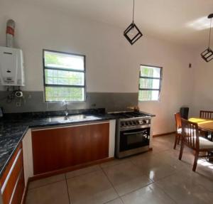 a kitchen with a stove and a dining room at Chalet Fratelli Rigoni in Villa Ciudad Parque