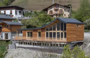 una casa de madera con techo negro en una colina en Chalet Sportif - Le Cotaret 14 Pax, en Bourg-Saint-Maurice