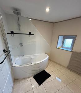 a white bathroom with a tub and a window at Maison avec jardin in Saint-Amand-sur-Sèvre +8 photos