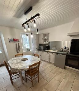 a kitchen with a table and a table and chairs at Maison avec jardin in Saint-Amand-sur-Sèvre