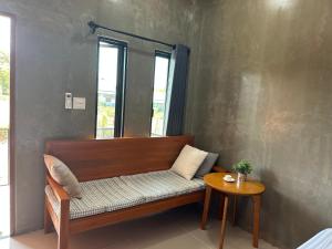 a bench in a room with a window and a table at Wisuthida Resort in Wang Saphung