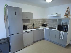 a kitchen with white cabinets and a refrigerator at Appartement Villeneuve in Villeneuve-de-Blaye +9 photos