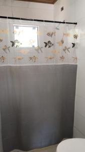 a bathroom with a shower curtain with fish on it at Residencial Bambu in Garopaba