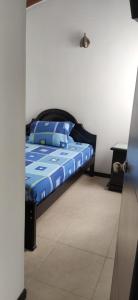 een bed met een blauw dekbed in een kamer bij Apartasol Familiar 2 in Santa Fe de Antioquia