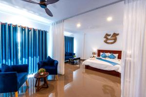 a bedroom with a bed and two blue chairs at Rithy Rin Angkor Hotel in Siem Reap +62 photos