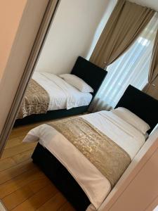 two beds in a small room with a window at VIP Apartment FOUR in Sarajevo