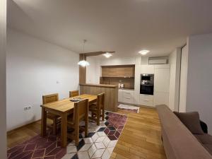 a kitchen and dining room with a table and a couch at VIP Apartment FOUR in Sarajevo