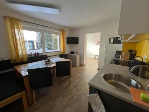 eine Küche mit Spüle und Tisch mit Stühlen in der Unterkunft Apart Aurelia in Längenfeld