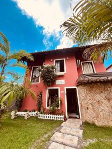 a pink house with palm trees in front of it at Pousada Brisa de Paraty in Paraty