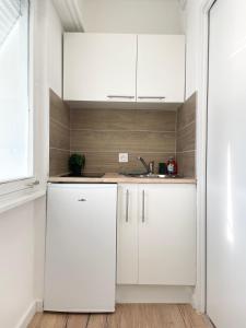 a kitchen with white cabinets and a sink at V5 Très Joli Studio proche Bâle in Saint-Louis