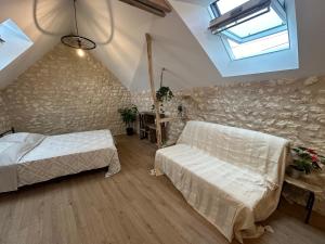 a attic bedroom with two beds and a window at Le Perchoir in Saint-Martin-le-Beau