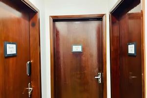 two wooden doors in a hallway with signs on them at 0001 - Pousada HG quarto home office, duplo in Vila Gopoúva