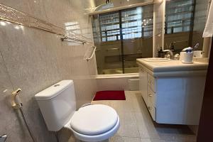 a bathroom with a white toilet and a sink at 0001 - Pousada HG quarto home office, duplo in Vila Gopoúva