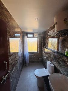 a bathroom with a toilet and a sink at Panchwati Farms Homestay in Almora
