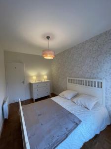 - une chambre avec un lit blanc et une commode blanche dans l'établissement Maison des Rêves de Loire, à Saint-Aignan