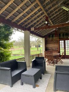 d'une terrasse avec des chaises, une table et un toit en bois. dans l'établissement Maison des Rêves de Loire, à Saint-Aignan