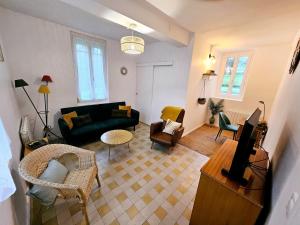 a living room with a black couch and chairs at Le Clos Bernadette in Boissy-le-Bois