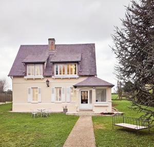 a white house with a black roof on a green field at Le Clos Bernadette in Boissy-le-Bois