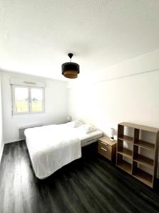 エオレにあるAigues Marines - Appartement spacieux avec parking et terrasseのベッドと窓のある白い寝室