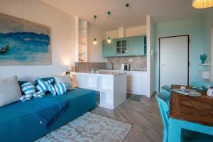 een woonkamer met een blauwe bank en een keuken bij Pandora Sea View by Solturelba in Capoliveri +26 foto's