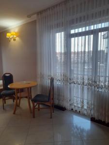 a dining room with a table and a large window at Perła in Leszno