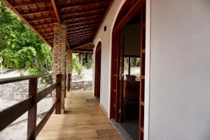 a porch of a house with a wooden walkway at Chalés Tucano Praia da Pipa - Natureza, Conforto, Tranquilidade in Pipa