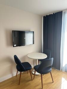 a room with a table and two chairs and a tv at Orbi City D2 in Batumi
