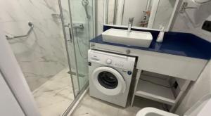 a bathroom with a washing machine and a sink at Orbi City D2 in Batumi +16 photos