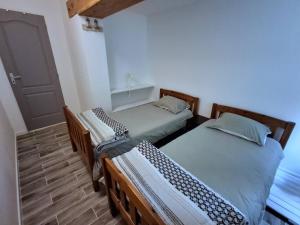 two twin beds in a room with a door at Appartement Villeneuve in Villeneuve-de-Blaye