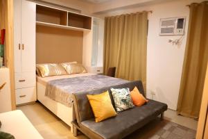 a small bedroom with a bed and a couch at Marilao Bulacan VIP flat in Lias