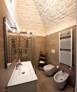 a bathroom with a sink and a toilet at Palazzo d'Itria - Luxury holiday in Valle d'Itria in Martina Franca