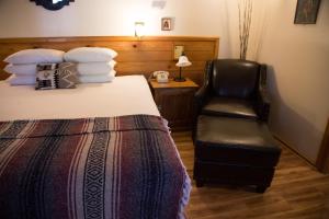 a hotel room with a bed, chair and a lamp at Sleepy Forest Cottages in Big Bear Lake