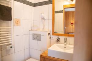 un bagno con lavandino e specchio di CHALET de charme 13 personnes avec Sauna SKI O PIEDS a Saint-Martin-de-Belleville Altre 64 foto