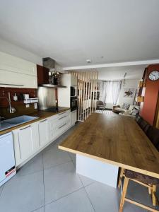 a kitchen with white cabinets and a wooden table at Chez Hélène et Jérémy in Montargis +4 photos
